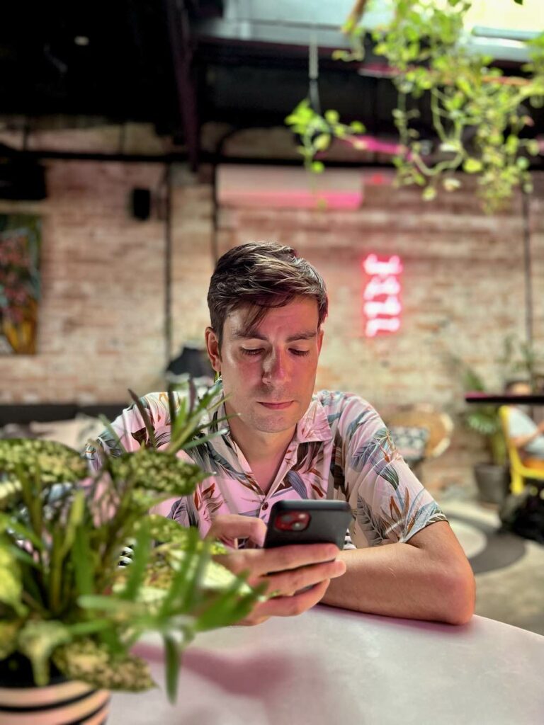 Matt working on his phone in a restaurant in Kuala Lumpur